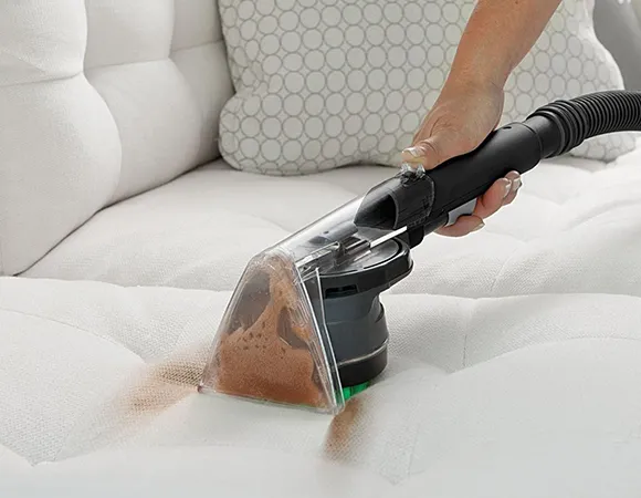 DEEP UPHOLSTERY CLEANING Technician applying fabric protection to couch in PA home